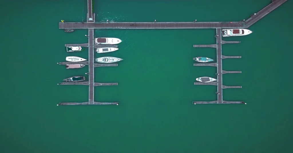 Boats moored at marina dock — ship parking management