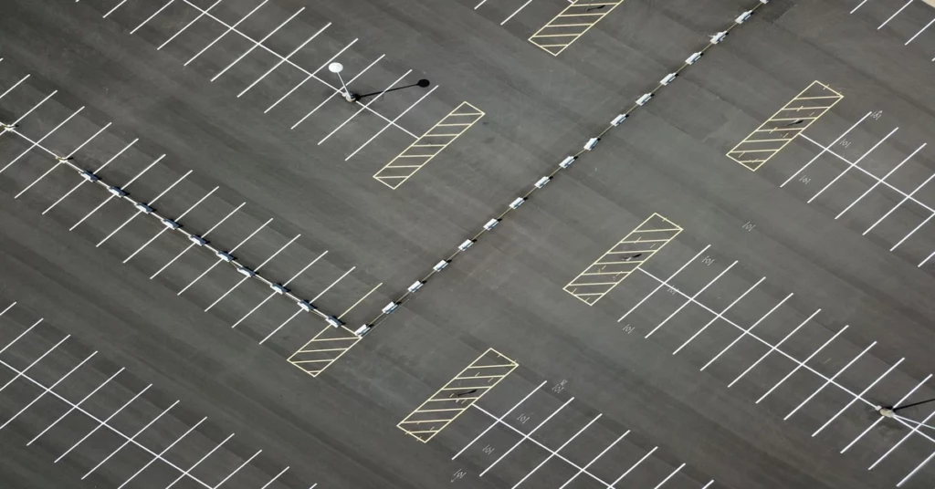 parking-occupancy-detection-cost-spaces-featured Top-down view of an empty outdoor parking lot with clearly marked spaces